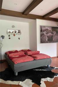 a bed in a bedroom with a picture of a cow on the wall at Ferienwohnung Alpenherz 80qm in Blaichach