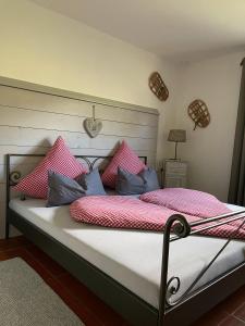 a bed with pink and blue pillows on it at Ferienwohnung Alpenherz 80qm in Blaichach