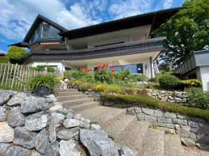 a house with a stone retaining wall and a stone staircase at Ferienwohnung Alpenherz 80qm in Blaichach