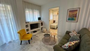 a living room with a green couch and a yellow chair at Inaya Home for you appt 3 Pièces Menton in Menton
