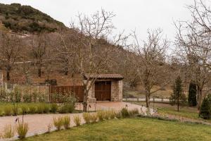 a stone building with a door in a garden at HERMEA Grand Mountain Villa & Spa in Feneos