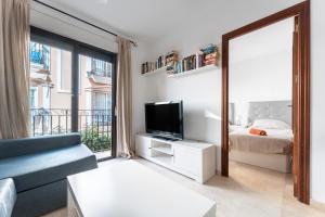 フエンヒロラにあるTown Apartment in Fuengirola Centreのリビングルーム(テレビ、ベッド、鏡付)