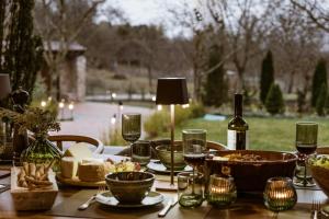 a wooden table with food and wine bottles and glasses at HERMEA Grand Mountain Villa & Spa in Feneos