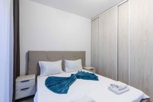 a bedroom with a bed with a blue towel on it at Sunny Side Wellness Resort & Spa in Budva