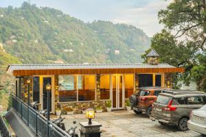 a house with two cars parked in front of it at Winterfell Stays Mussoorie in Mussoorie