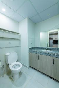 une salle de bain blanche avec toilettes et lavabo dans l'établissement scandic resort 647, à Hurghada