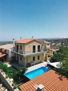 a villa with a swimming pool and a house at Emily Maria Fine Living in Filakí