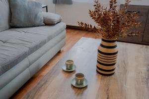 a coffee table with two cups and a vase at Bessemer - Charming Cottage with Garden in Vienna