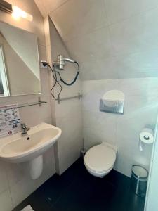 a small bathroom with a toilet and a sink at Hotel Nad Stawem in Bogacica +13 photos