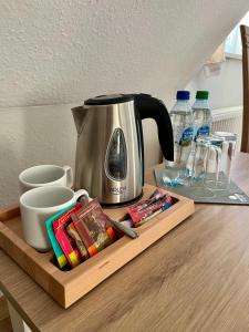a coffee maker on a wooden tray on a table at Hotel Nad Stawem in Bogacica