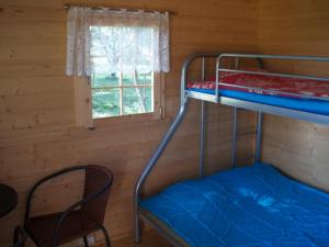 a bunk bed in a log cabin with a window at Ula-Hansu talu in Suur-Rootsi