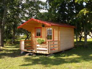 a small wooden house with a red roof at Ula-Hansu talu in Suur-Rootsi