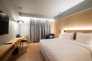 a hotel room with a large bed and a desk at Magnes Hotel in Volos