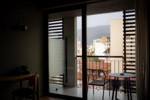 a room with a balcony with a table and a view at Magnes Hotel in Volos