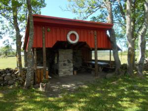 a red cabin with a bench in a field at Ula-Hansu talu in Suur-Rootsi