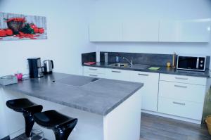 a white kitchen with a counter and a microwave at Bonsai-Ferienwohnung in Bad Laer
