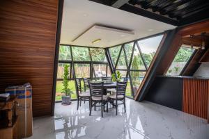 Un comedor con mesa y sillas y ventanas. en A Skylight Cabin, en Santo Tomás