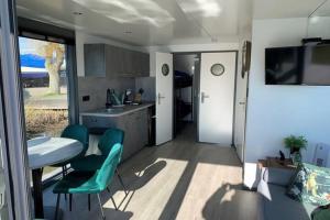 a kitchen with a table and two chairs and a table at Houseboat Tulip NS006 in Monnickendam +8 photos