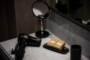 a black hair dryer and a mirror on a counter at Magnes Hotel in Volos