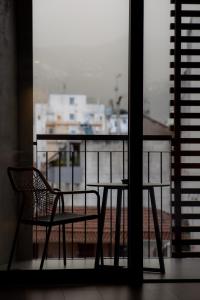 a table and a chair sitting on a balcony at Magnes Hotel in Volos