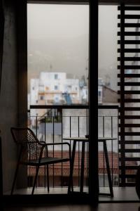 a table and a chair sitting on a balcony at Magnes Hotel in Volos