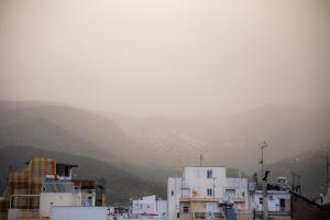 a group of white buildings with mountains in the background at Magnes Hotel in Volos