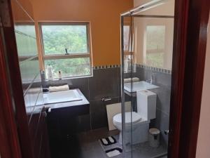 a bathroom with a toilet and two sinks and a window at 4C On Gillian in Sandton +30 photos