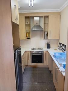 a kitchen with wooden cabinets and a stove top oven at 4C On Gillian in Sandton