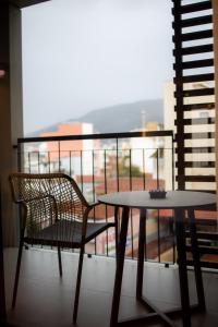 a table and a chair on a balcony with a view at Magnes Hotel in Volos