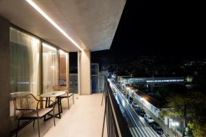 a balcony with a table and chairs and a city at Magnes Hotel in Volos