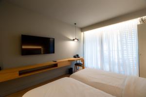 a bedroom with a bed and a tv and a window at Magnes Hotel in Volos