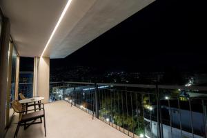 a balcony with a view of the city at night at Magnes Hotel in Volos