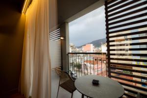 a balcony with a table and a large window at Magnes Hotel in Volos
