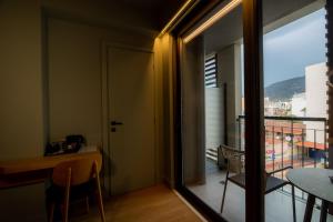 a room with a view of a balcony with a table and chairs at Magnes Hotel in Volos
