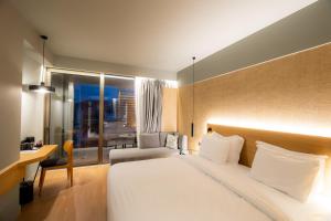 a bedroom with a large white bed and a desk at Magnes Hotel in Volos