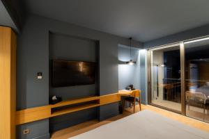 a living room with a tv on a wall at Magnes Hotel in Volos
