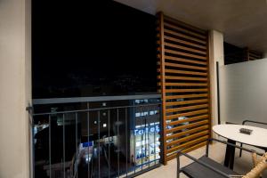a room with a balcony with a view of the city at Magnes Hotel in Volos
