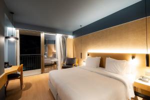 a hotel room with a large bed and a desk at Magnes Hotel in Volos