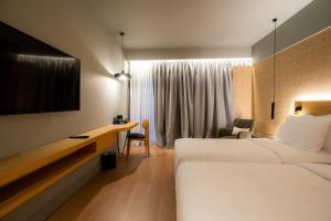 a hotel room with a bed and a television at Magnes Hotel in Volos