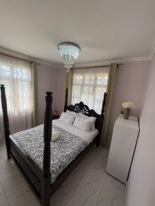 ein Schlafzimmer mit einem Bett und einem Kronleuchter in der Unterkunft JPAL Properties in Kisumu