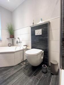 a bathroom with a toilet and a tub and a sink at Ferienwohnung im Grießetal in Aerzen