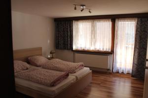 מיטה או מיטות בחדר ב-Ferienwohnung Silberdistel, Saastalstrasse 178