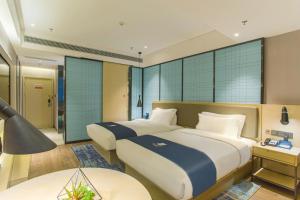 Voodi või voodid majutusasutuse Echarm Hotel Hezhou Avenue toas
