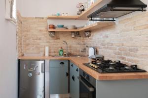 a kitchen with a stainless steel stove and a brick wall at Bertos Balcony In The Heart Of Canal D Amour in Sidari
