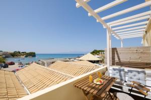 a balcony with a table and a view of the beach at Bertos Balcony In The Heart Of Canal D Amour in Sidari
