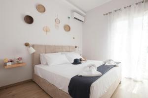 a bedroom with a large white bed with towels on it at Bertos Balcony In The Heart Of Canal D Amour in Sidari