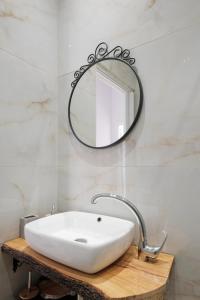 a bathroom with a white sink and a mirror at Bertos Balcony In The Heart Of Canal D Amour in Sidari +10 photos