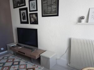 a living room with a flat screen tv on a wall at Charmante maisonnette de caractère in Châteauroux