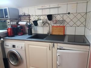 a kitchen with a sink and a washing machine at Charmante maisonnette de caractère in Châteauroux