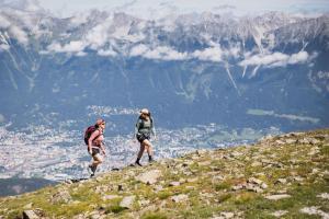 two people walking on top of a mountain at Kaiser Max Design Appartements in Innsbruck